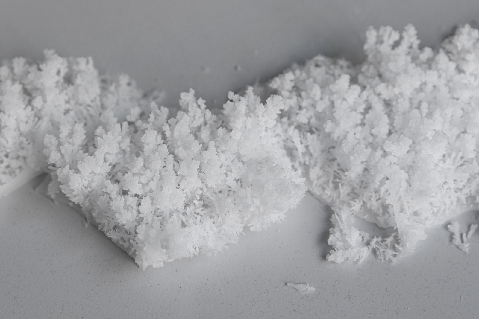 White powder resembling frosted snow on a synthetic grey background