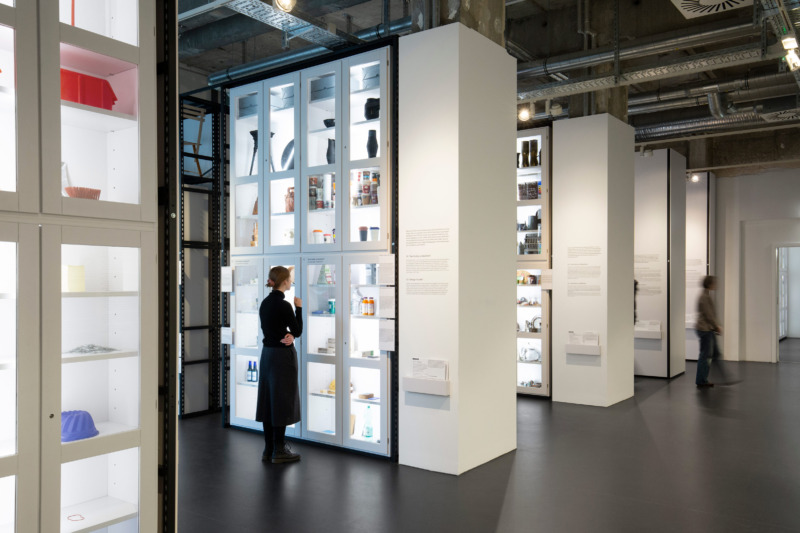 A visitor stands in front of a white display case in the new permanent exhibition.