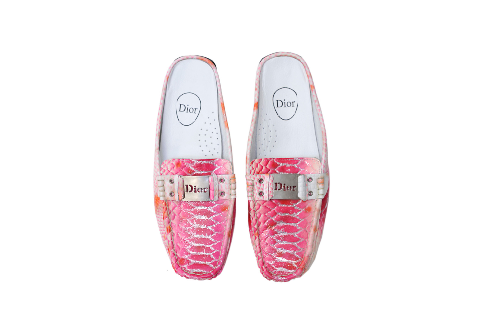 A pair of counterfeit Dior slip-ons in a pink snakeskin-effect finish, featuring silver glitter details and a logo buckle.