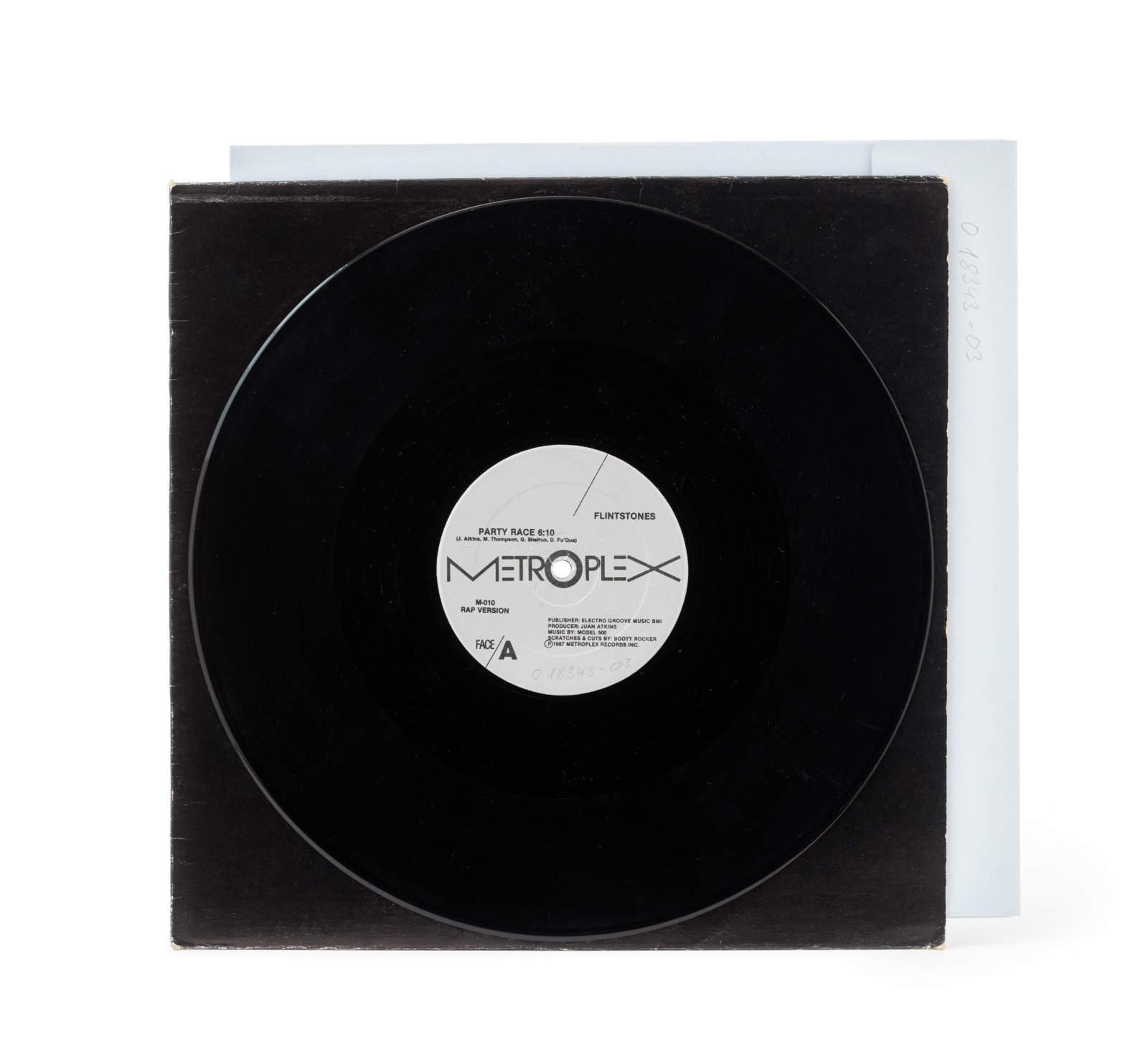 A black vinyl record with a white Metroplex label on top of a black inner sleeve and a white outer envelope.